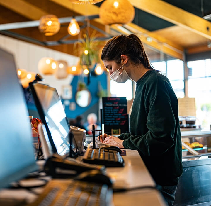 Eladó maszkban egy élelmiszerboltban